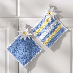 two crocheted blue and yellow items hanging on the wall