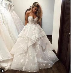 a woman is taking a selfie in front of wedding gowns on the phone