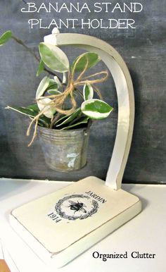 a potted plant sitting on top of a white table next to a chalkboard