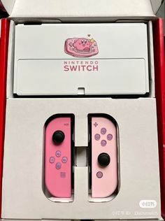 two nintendo wii game controllers sitting in a box with pink and white designs on them