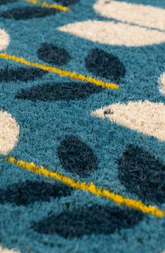 a blue rug with yellow and white designs on it's edges is seen in close up