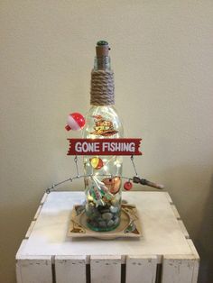 there is a bottle with fishing related items in it on top of a small table