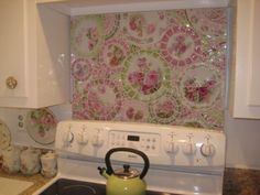 a tea kettle sitting on top of a stove next to a wall covered in tiles