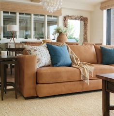 a living room filled with furniture and a chandelier hanging from the ceiling next to a window