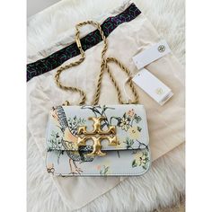 This Beautiful Tory Burch Eleanor Brocade Crossbody Small Shoulder Bag Is Sure To Be Your New Favorite Accessory. The Stunning Floral Pattern And Sunset Bonfire Suede Exterior Make For A Fashionable Statement Piece. The Brass Crossbody Strap And Gold Hardware Give This Bag An Elegant Touch. With A Magnetic Snap Closure And Dimensions Of 7.8" X 5.4" X 2.8", This Shoulder Bag Is The Perfect Size To Hold All Of Your Essentials. The Green Lining And Flower/Bird Theme Add Even More Charm To This Alre Tan Rectangular Bag With Chain Strap, Designer Tan Bags With Chain Strap, Tan Travel Bag With Chain Strap, Tory Burch Kira Chevron, Tory Burch Crossbody Bag, Tory Burch Shoulder Bag, Kira Chevron, Tory Burch Crossbody, Tory Burch Wallet