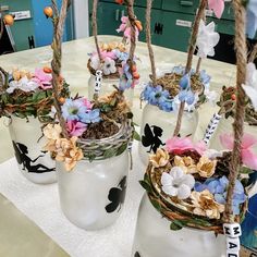 four mason jars with flowers in them sitting on a table