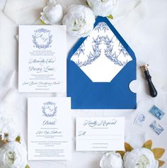 a blue and white wedding suite with matching envelopes, cards, and stationery