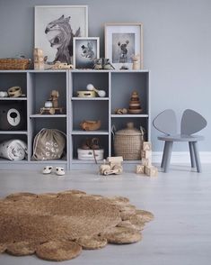 a living room filled with furniture and pictures on the wall next to a rug in front of a book shelf