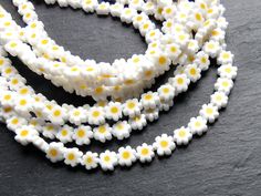 Affordable alternative glass flower beads. Great for this year's dainty beaded chokers/bracelets trend. Quantity: 1 strand  = 48cm = 15 inches - Approx 50 pieces per strand Shape: Mini daisy Flower Size: approx. 7-8mm with 0.08mm hole Color: white and yellow Please note: As these are individually handmade, there may be a very slight difference in size and color :) White Flower Spacer Beads, White Flower Shaped Beads For Jewelry Making, Adjustable White Flower-shaped Beaded Necklaces, Adjustable White Flower Beaded Necklaces, Trending Bracelets, Flower Beads, Support Handmade, Beaded Choker, Daisy Flower