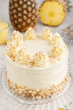 there is a white cake with pineapples around it