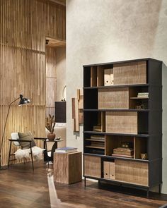 a living room filled with furniture and a wooden wall next to a lamp on top of a hard wood floor