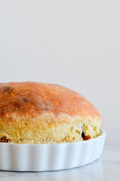 a close up of a baked item in a dish on a white counter top with a gray background