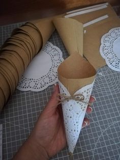 someone is making some paper cones out of brown and white doily with twine