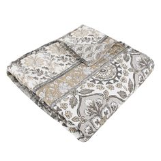 a white and brown blanket on top of a bed with paisley print design in the middle