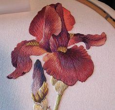 a close up of a flower embroidered on a piece of cloth