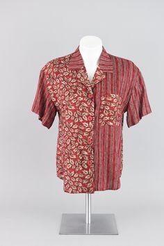 Vintage short sleeve shirt with medium sized textured red buttons down the front. Blend of red, tan and black colors in a mixed pattern of leaves and geometric dotted stripes. Casual fold over double tiered lapel and a right chest pocket. Includes shoulder padding too! This top is made from soft rayon and has a relaxed fit to it.   Brand Norton McNaughton Petites // Made in USA // 80s - 90s era Condition Great condition No rips, tears or stains Hand wash only instructions, line dried & ready to Short-sleeve Tops With Geometric Pattern, 90s Jean Dress, 90s Era, Floral Button Up, Vintage Short, Vintage Pants, Button Up Blouse, Long Sleeve Knit Tops, Red Shorts