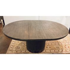 an oval wooden table on top of a rug