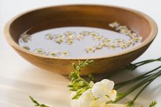 white flowers and water in a wooden bowl