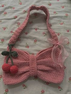 a pink crocheted purse with cherries on it