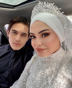 a man and woman are posing for a photo in the back seat of a car