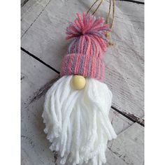 a white and pink hat ornament hanging from a string