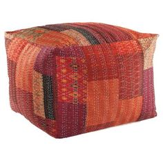 an orange and red patchwork square pillow