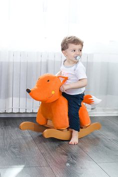 a little boy sitting on top of a stuffed animal toy with a pacifier in his mouth