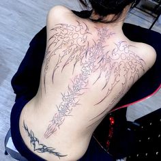 the back of a woman's body with tattoos on it