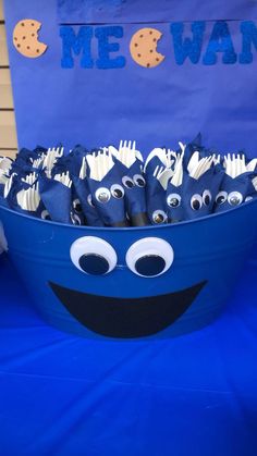 a blue bucket filled with paper plates and forks