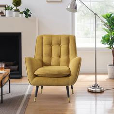 a yellow chair sitting in front of a fire place next to a table with a potted plant on it