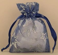 a blue bag with white stars on it and a ribbon tied around the bottom is sitting on a table