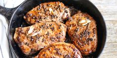 four pieces of meat in a skillet on a table