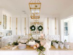 a kitchen with white cabinets and gold accents