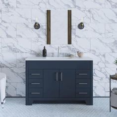 a bathroom with marble walls and flooring, two mirrors on the wall above the sink