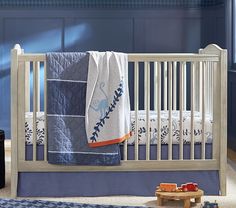 a baby crib with blue and white decor