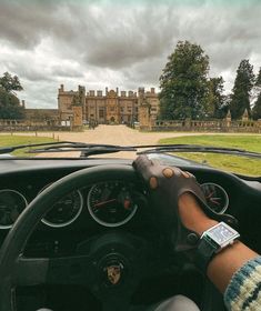 a person driving a car in front of a castle