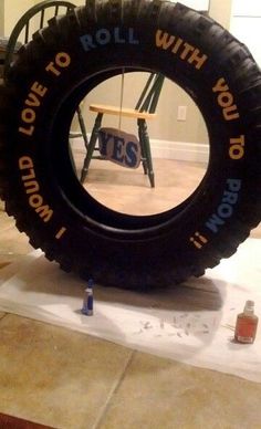 a giant tire sitting on top of a floor next to a table with writing on it