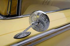 the door handle on an old yellow car is decorated with intricate designs and ornate details