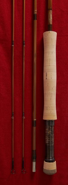 three different types of fishing rods on a red cloth with two poles attached to them