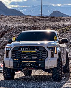 a white truck parked on top of a rocky hill