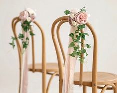 three wooden chairs with flowers and ribbons on them