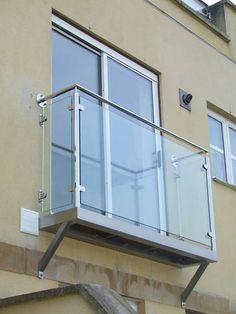 a balcony on the side of a building with glass balconies and railings