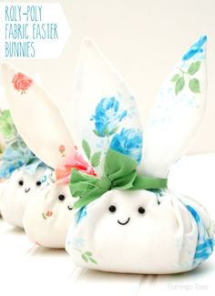 four white bunny bunnies with blue flowers and green leaves on them, sitting side by side