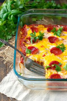 a square casserole dish with pepperoni and cheese on top, garnished with parsley