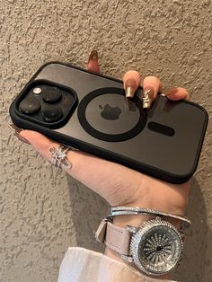 a woman holding an iphone case with two rings on her wrist and one ring in the other hand