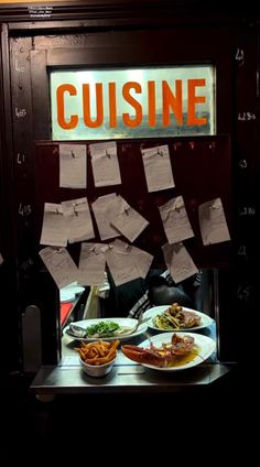 a table topped with plates of food next to a sign that says cuisine on it