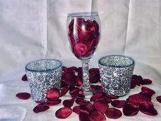 two wine glasses with silver glitter and red rose petals