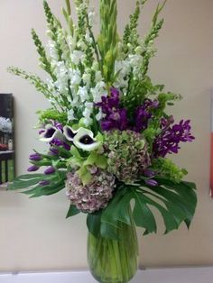 a vase filled with lots of purple and white flowers