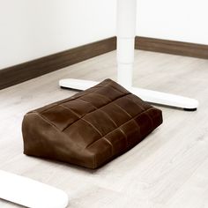 a brown leather cushion sitting on the floor