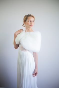 a woman in a white dress and fur stole